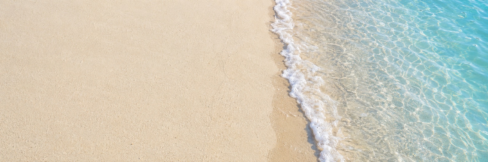 Clear turquoise water meeting a pale sandy shoreline